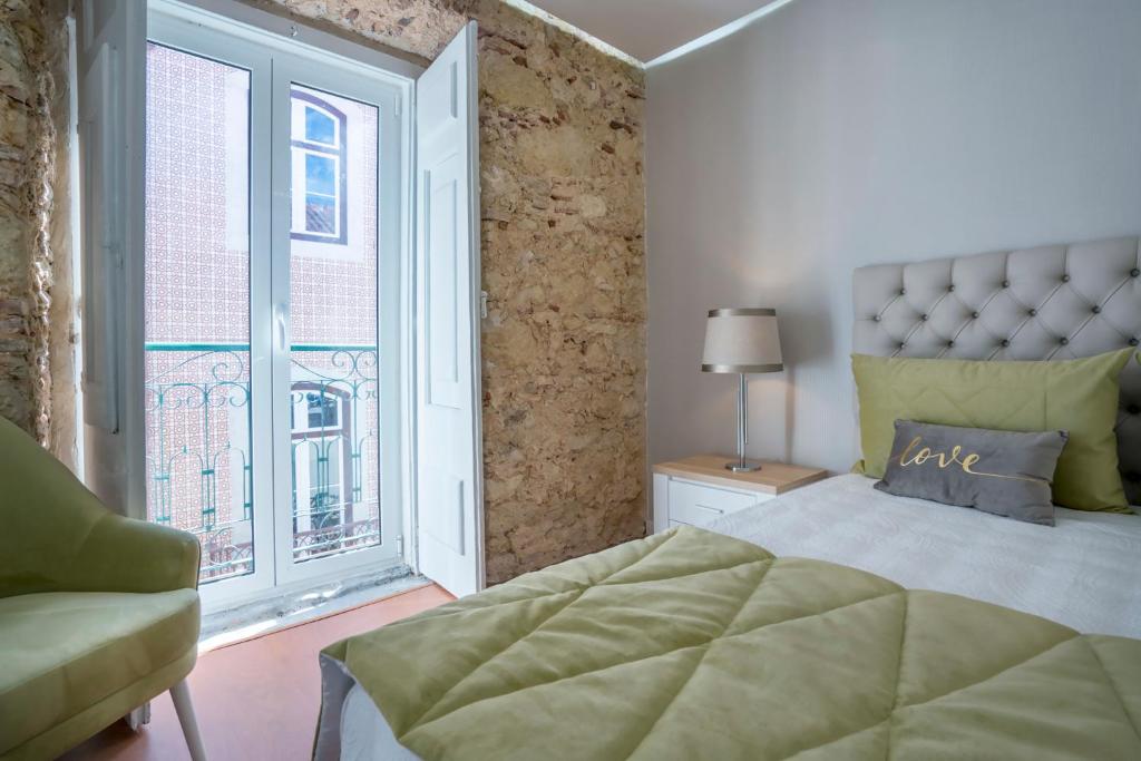 a bedroom with a bed and a large window at Brand New Downtown Apartment in Lisbon