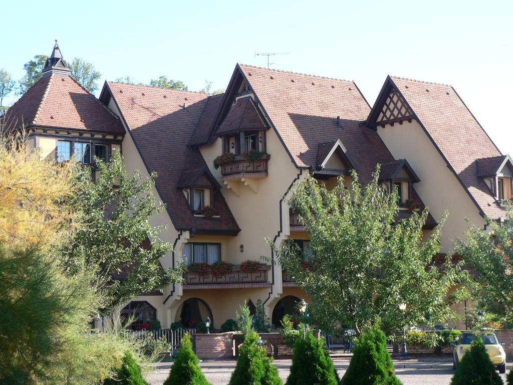 a large house with tiled roofs at Hotel Le Mandelberg in Mittelwihr