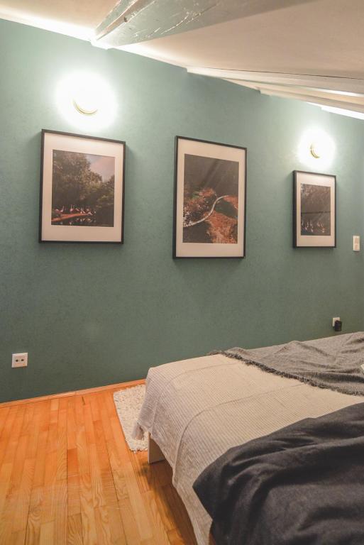 a bedroom with three pictures on a green wall at Apartments Lucija in Zadar