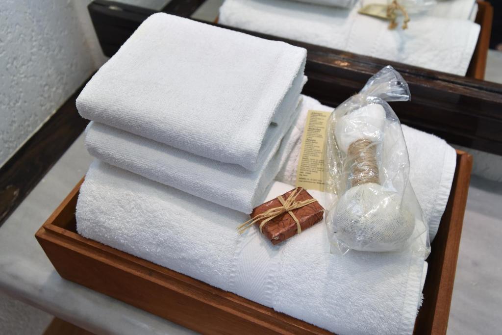 a wooden box with towels and a bottle of perfume at Guest House Jedro in Petrovac na Moru