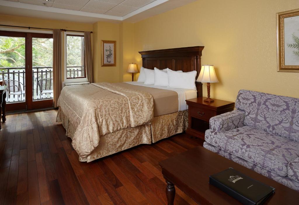 a bedroom with a bed, chair and a lamp at Ocean Inn & Suites in Saint Simons Island