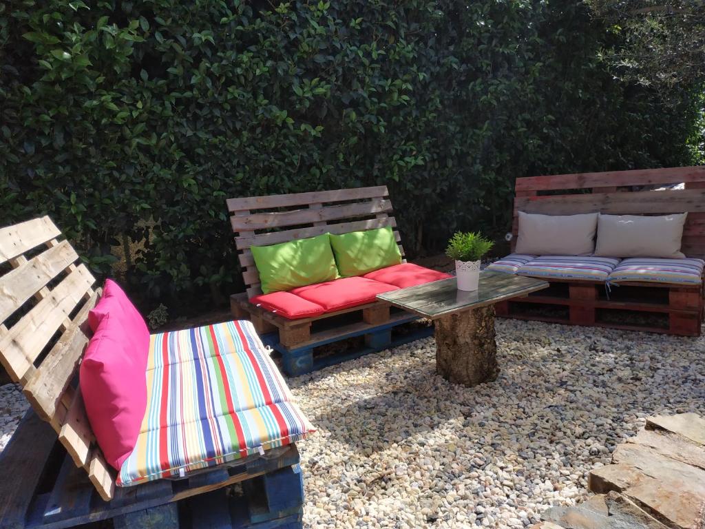 カセレスにあるEl Olivarのカラフルな枕が備わるベンチ2台(テーブルの横に座る)