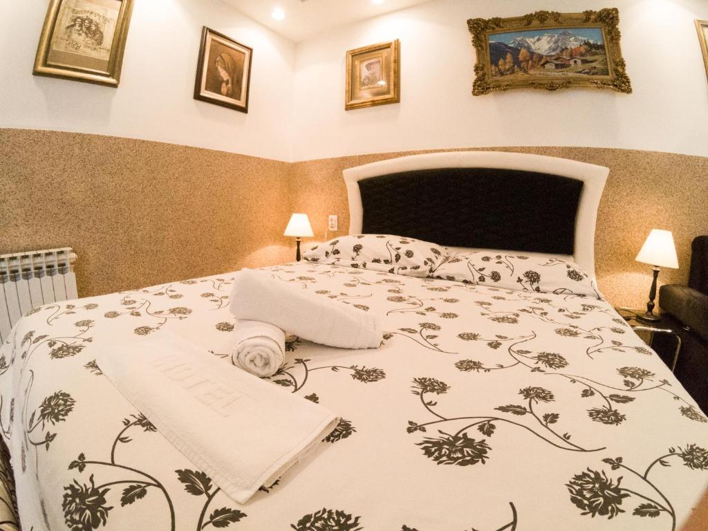 a bedroom with a bed with a flowered bedspread at Top Centar Liberty in Banja Luka