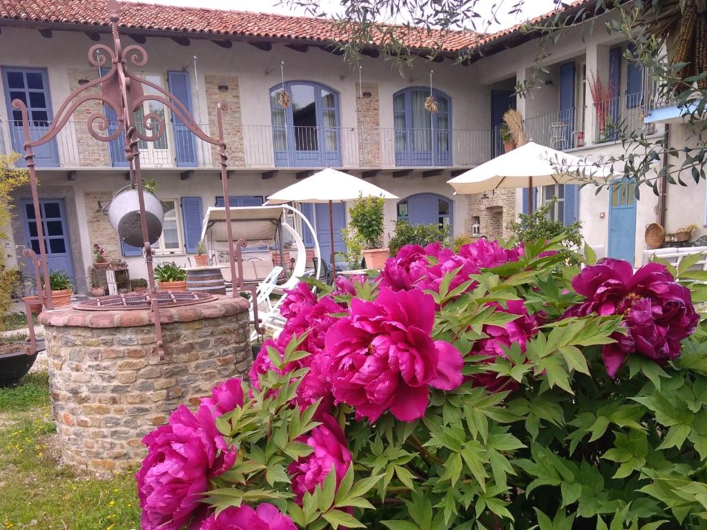 dom z różowymi kwiatami przed nim w obiekcie Cascina Giardini w Albie