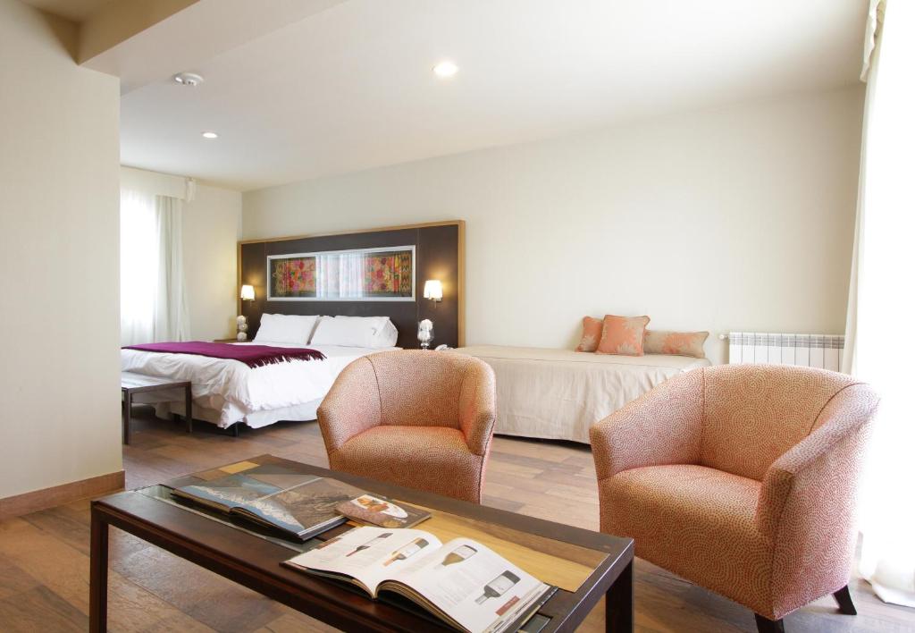 Habitación de hotel con cama, 2 sillas y mesa en Plaza Paradiso Petit Hotel en Chacras de Coria