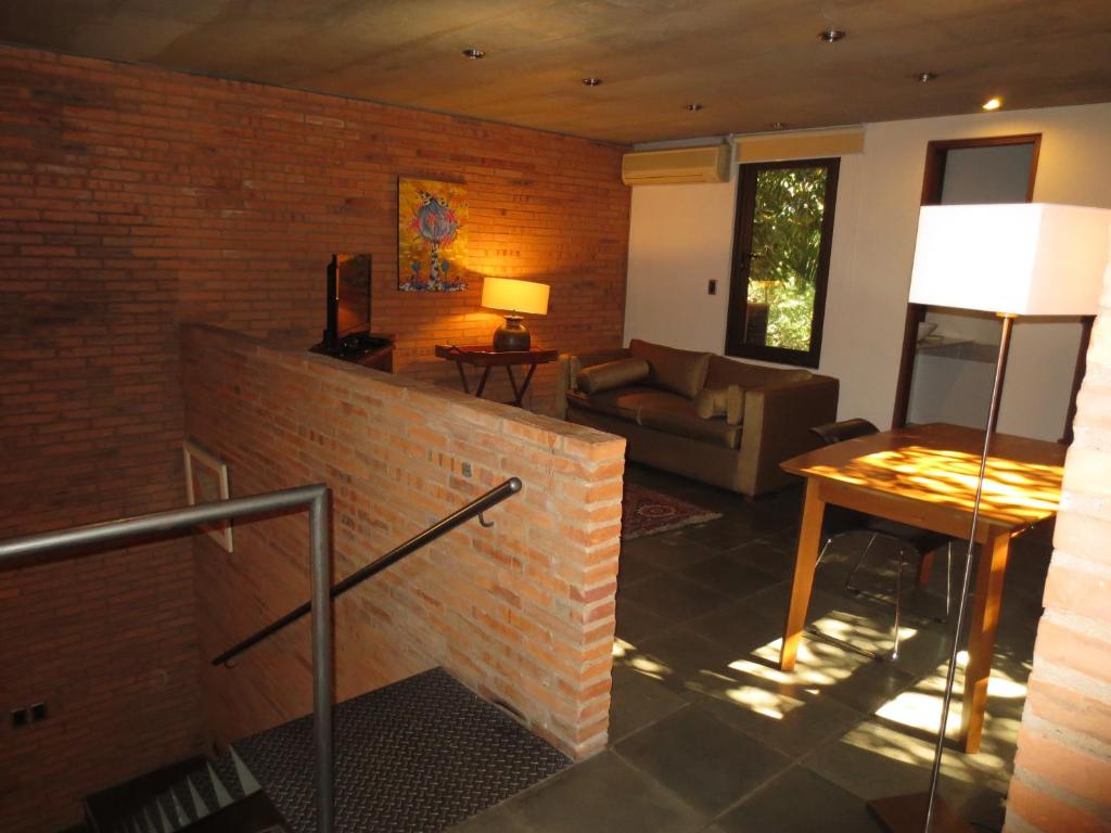 sala de estar con pared de ladrillo y sofá en Loft La Morada, en Asunción