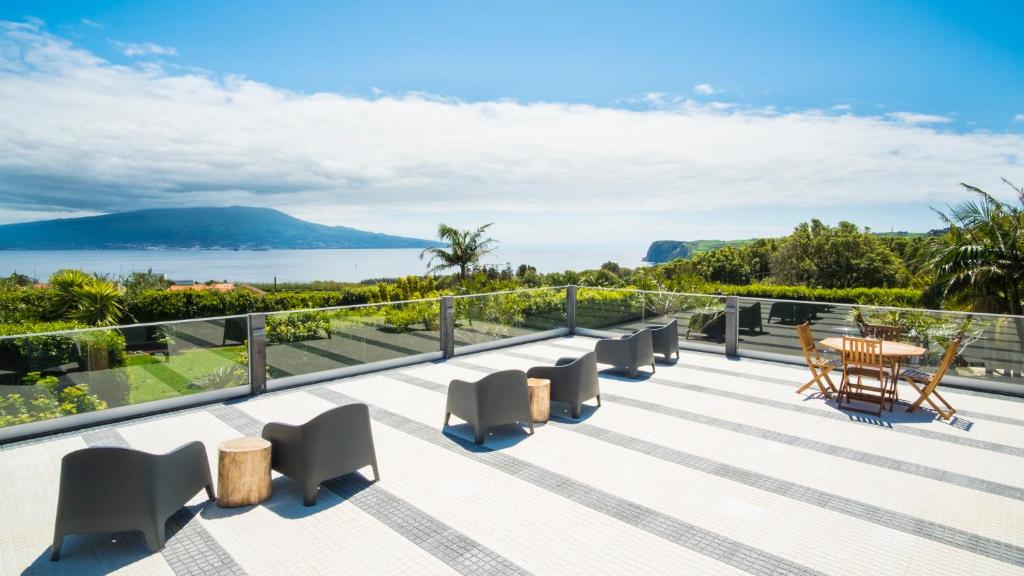 Un balcón con sillas y vistas al océano. en Quinta do Torcaz en Horta
