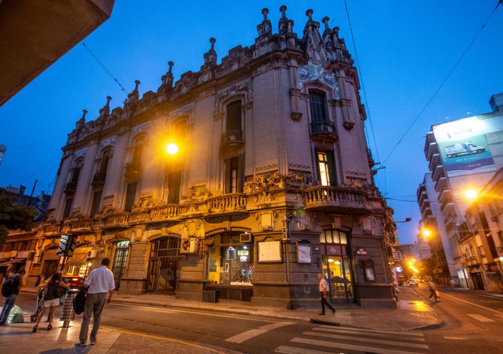 un grand bâtiment situé dans une rue de la ville la nuit dans l'établissement High Hostel Rosario, à Rosario