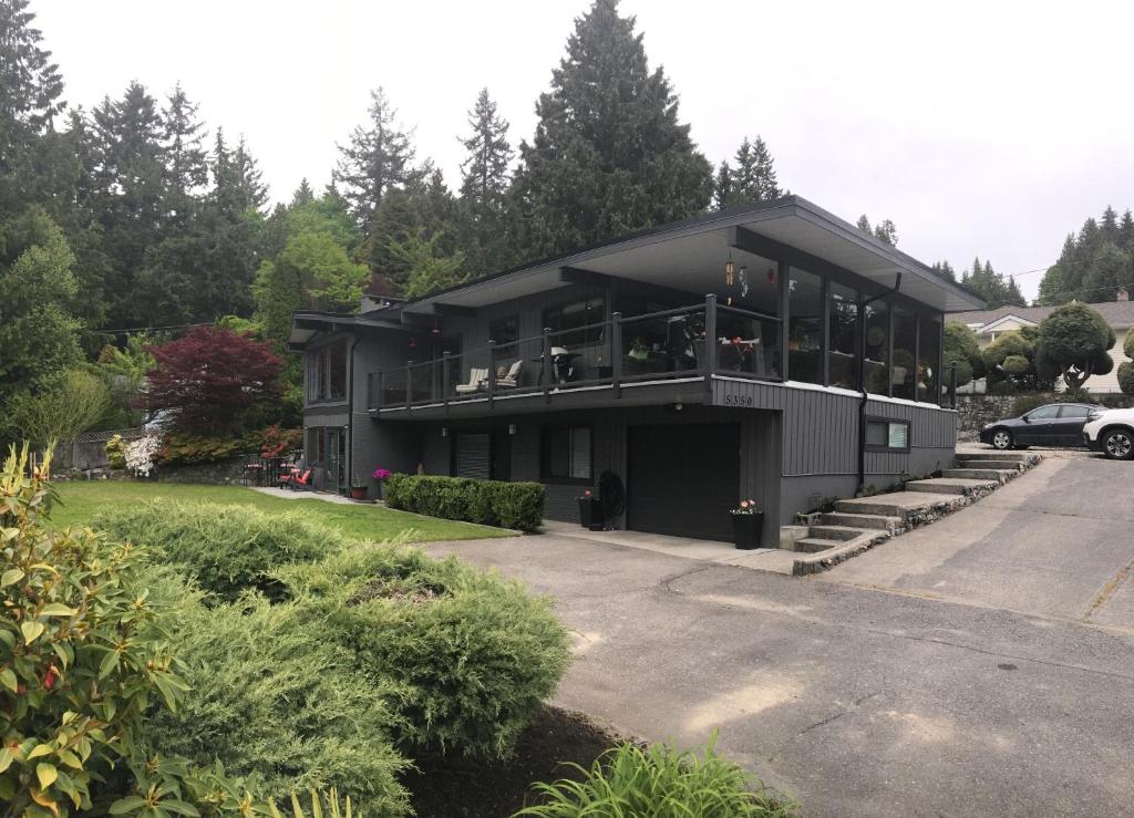 a large black house with people sitting on the balcony at Gone Coastal in Sechelt