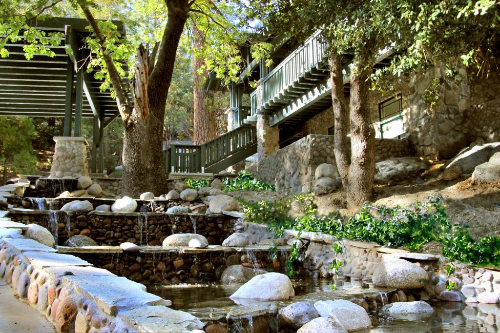 a pond in a garden with rocks and trees at The Grand Idyllwild Lodge in Idyllwild