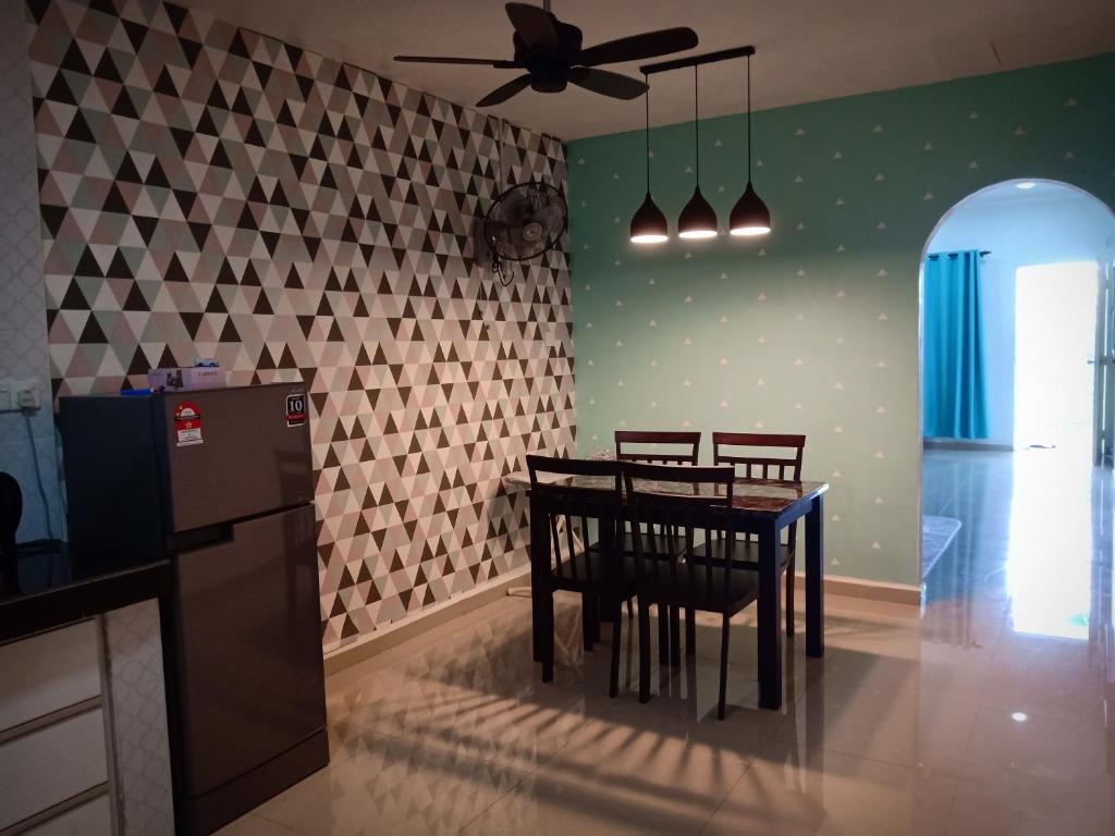 a dining room with a table and a ceiling fan at AZURE SKY HOMESTAY KUALA SELANGOR in Kuala Selangor