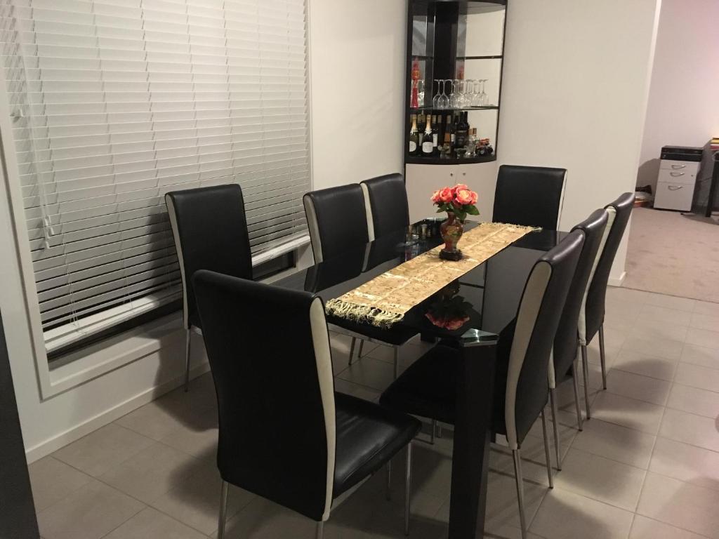 comedor con mesa y sillas negras en Melbourne Lakes warm house, en Melbourne
