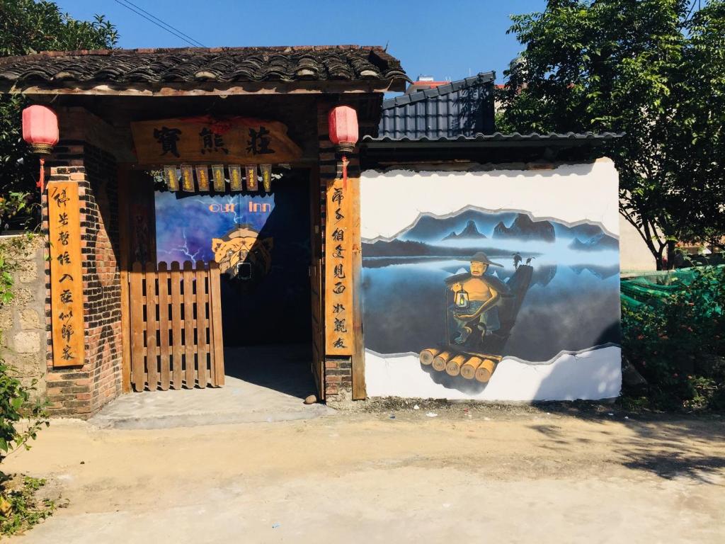 Una puerta a un templo con un cuadro. en Xingping Our Inn, en Yangshuo