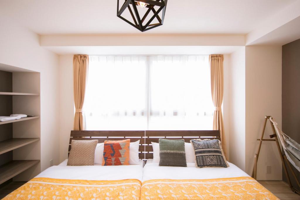 大阪Minn Umeda North的一间卧室，配有一张床、枕头和一扇窗户