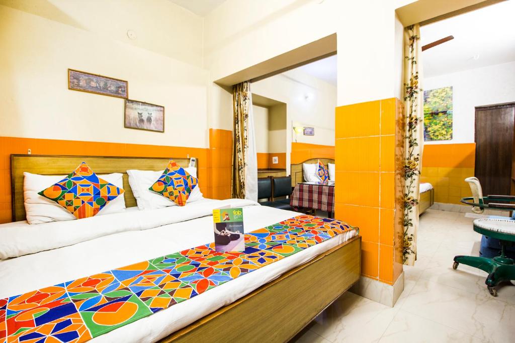 a bedroom with a bed and a mirror at Hotel Ashrey in Dehradun