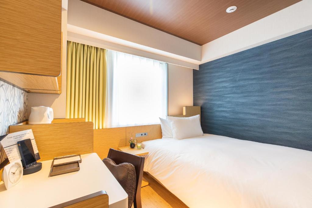 Postel nebo postele na pokoji v ubytování Daiwa Roynet Hotel Nagoya Fushimi