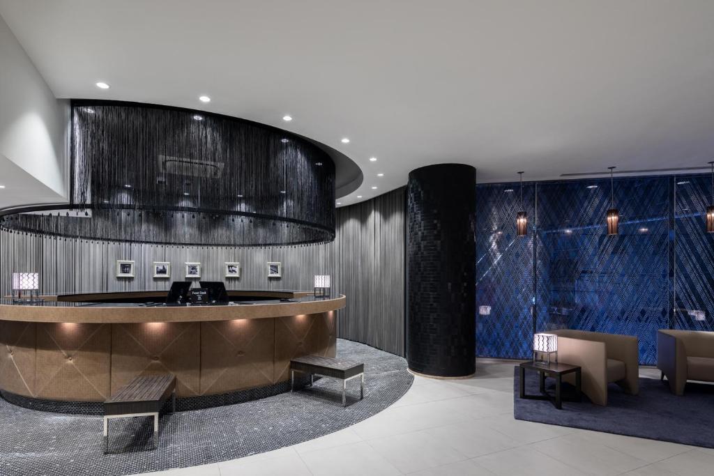 a lobby with a reception desk and chairs and a large ceiling at Hotel MYSTAYS PREMIER Dojima in Osaka