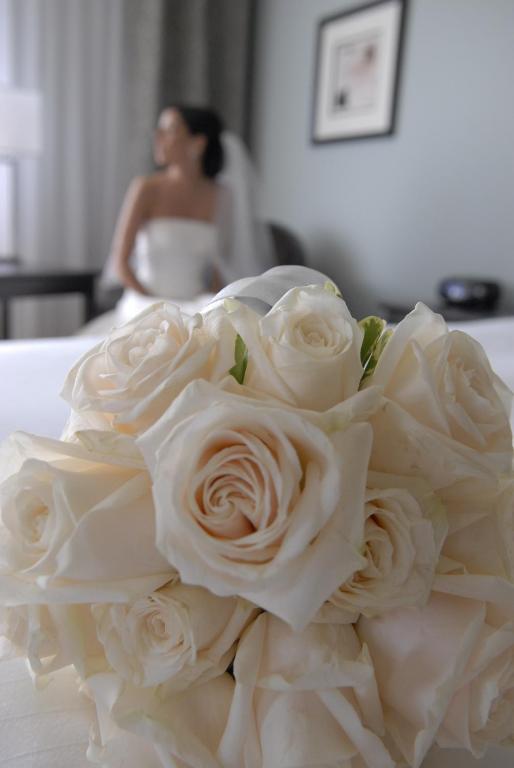 a bouquet of white roses with a bride in the background at Imperia Hotel & Suites Saint-Eustache in Saint-Eustache