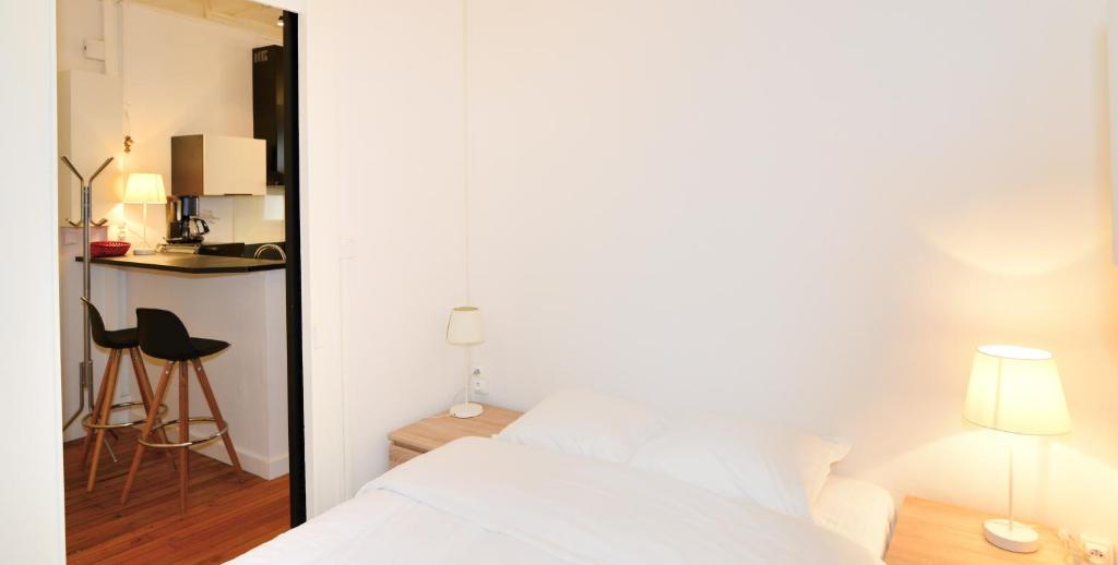 a bedroom with a white bed and a table at Appart' Gailleton in Lyon