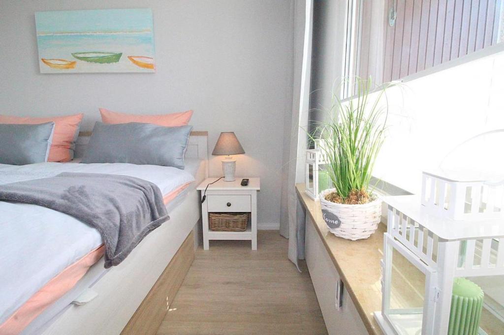 ein kleines Schlafzimmer mit einem Bett und einem Fenster in der Unterkunft Appartementvermittlung Mehr als Meer Objekt 36 in Niendorf