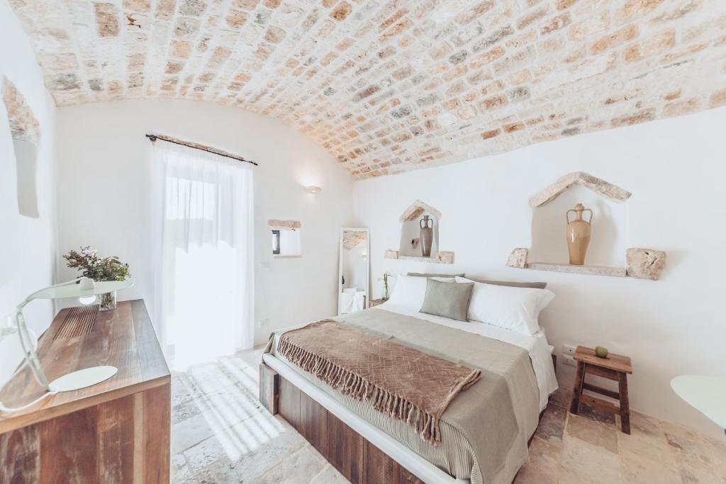a white bedroom with a bed and a sink at Borgo Canonica in Cisternino