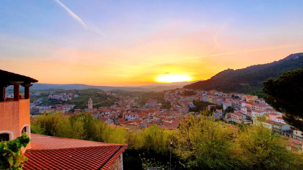 een uitzicht op een stad met de zonsondergang op de achtergrond bij Hotel Su Lithu in Bitti