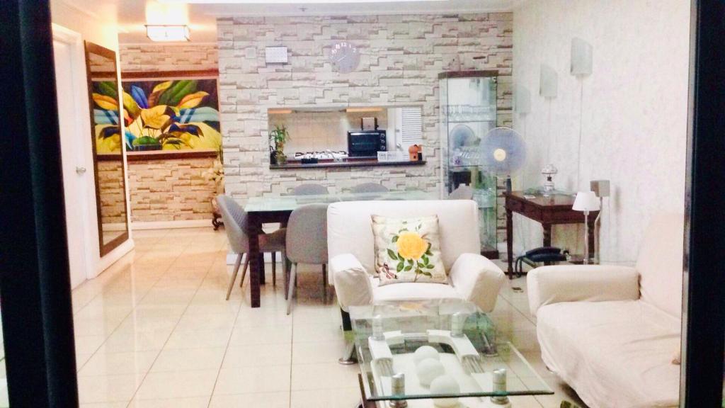een woonkamer met een bank en een tafel en stoelen bij 67 sqm. Condo Unit in Robinson Place Residences in Manilla