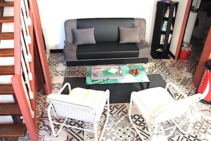 a living room with a couch and a table and chairs at Le Duplex du Mole in Sète