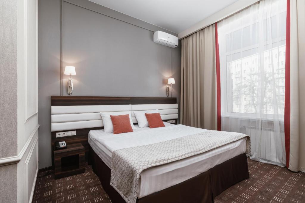 モスクワにあるホテル ソコルのベッドと大きな窓が備わるホテルルームです。