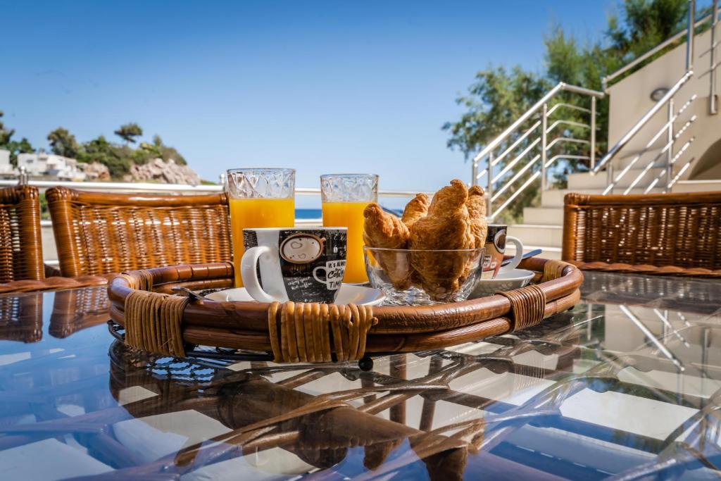 uma mesa com uma bandeja de pão e dois copos de cerveja em Theaktis Homes em Kaloí Liménes