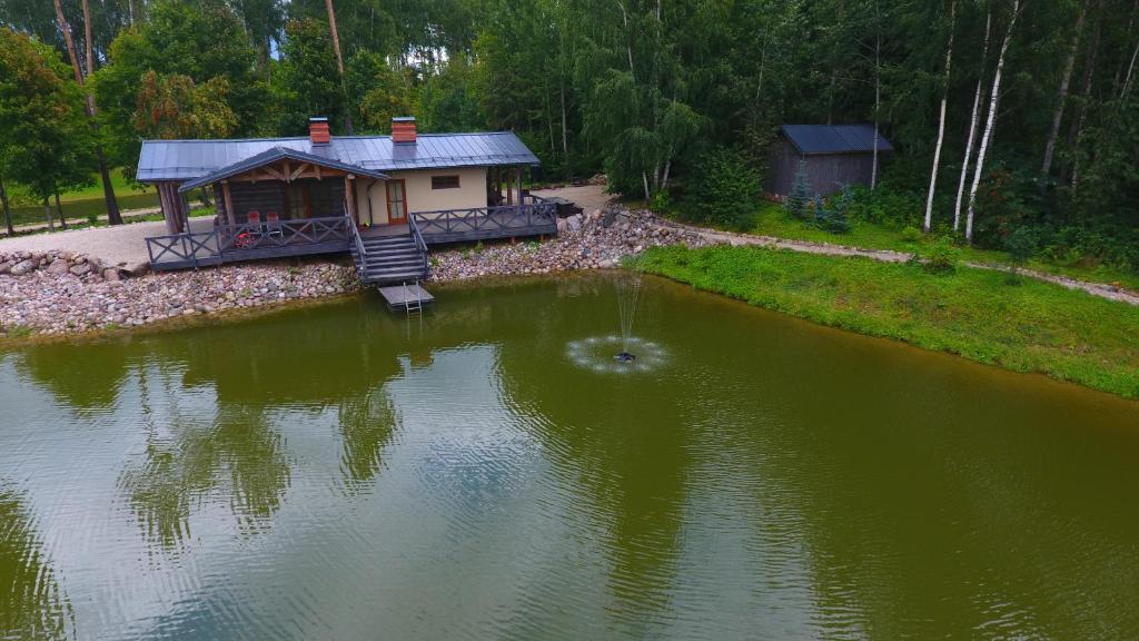 una pequeña casa en medio de un lago en Dzirnavas Pirtsmāja, en Cesvaine