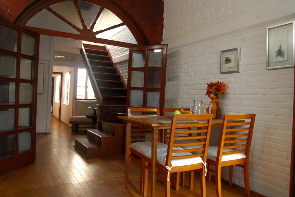 een eetkamer met een tafel en stoelen en een trap bij Coyoacan, 2 level Cozy apartment 3Bedrooms, 3Bathrooms, Terrace in Mexico-Stad