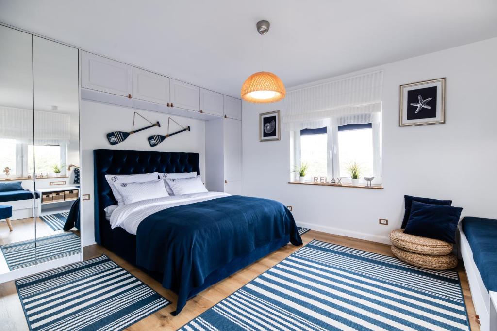 ein Schlafzimmer mit einem großen Bett und einem Sofa in der Unterkunft Blue Marine Apartament 19 z tarasem in Rowy