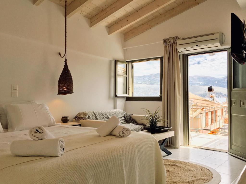 a bedroom with a large bed and a large window at Alkestis Studios in Lixouri