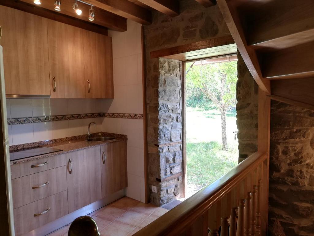 a kitchen with a sink and a window in a house at Casa Rural LA HUERTA DE POTES in Cabezón de Liébana