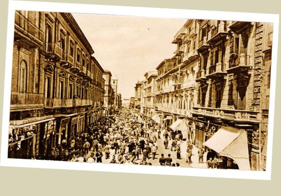 una vecchia foto di una folla di persone che camminano per strada di Borgo Due Mari a Taranto