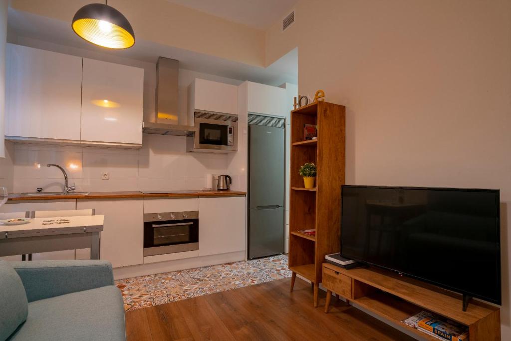 sala de estar con TV y cocina en For You Rentals Chueca Apartment BRC42, en Madrid