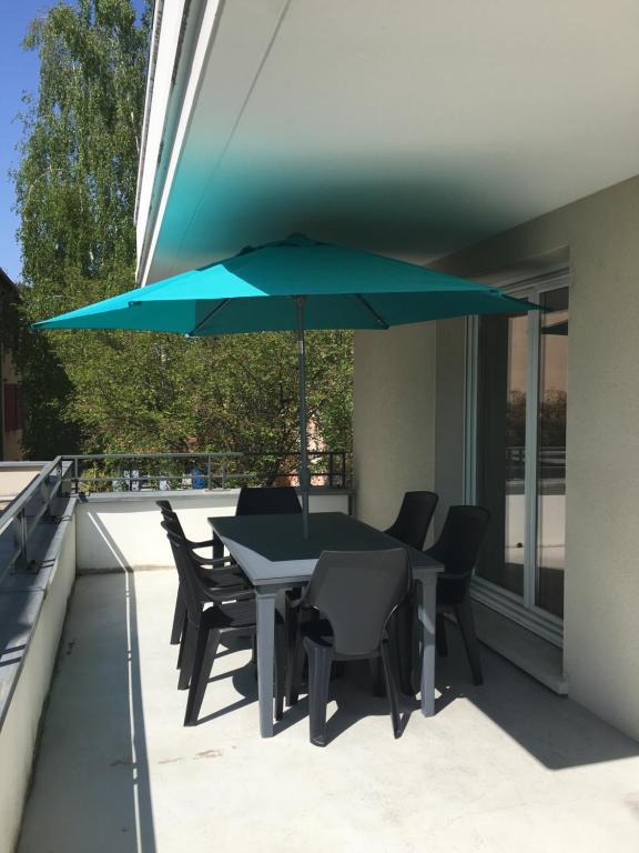 ストラスブールにあるJoli 3P avec terrasse et Garage proche Centreのパティオ(テーブル、椅子、青い傘付)