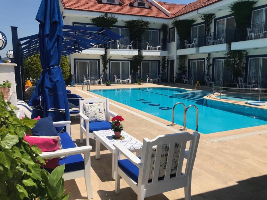 einen Pool in einem Hotel mit Stühlen und einem Tisch in der Unterkunft Rota Hotel in Dalyan