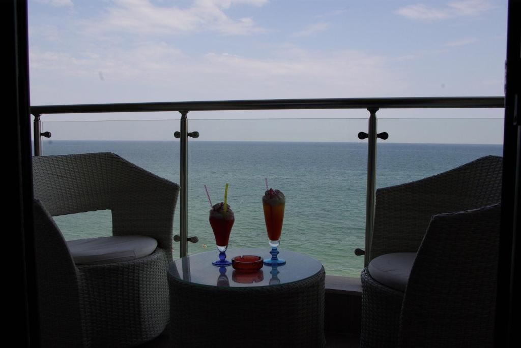 two drinks on a table in front of the ocean at Dion Hotel in Paralia Katerinis