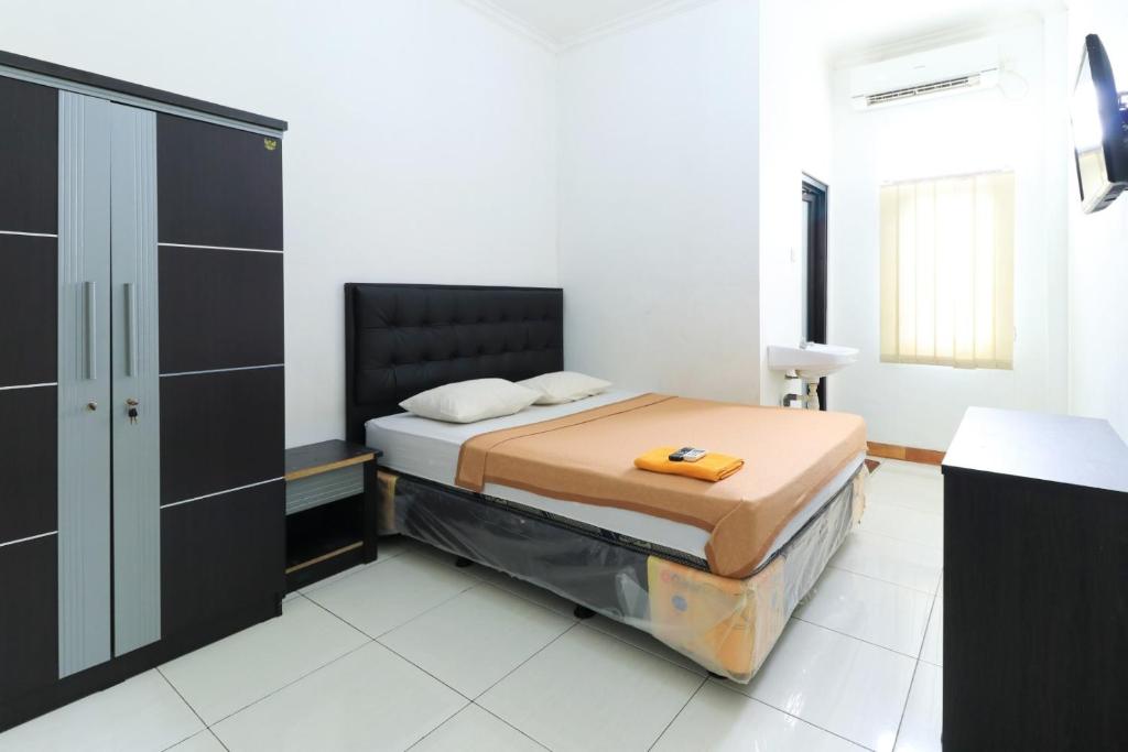 a bedroom with a bed and a cabinet in it at Riviera Residence in Balikpapan