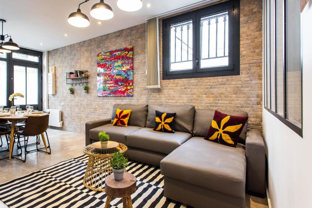 a living room with a couch and a brick wall at CMG Marché d'Aligre - Nation G in Paris