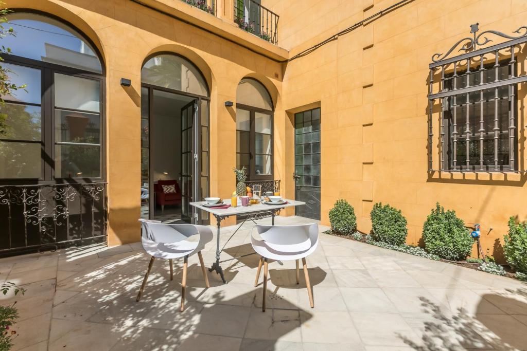 a patio with a table and chairs in front of a building at Casa Temprado in Seville