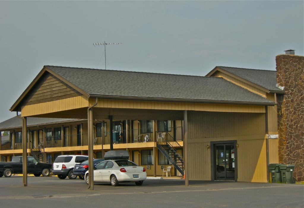 un edificio con coches estacionados en un estacionamiento en Red Lion Inn and Suites La Pine, Oregon, en La Pine