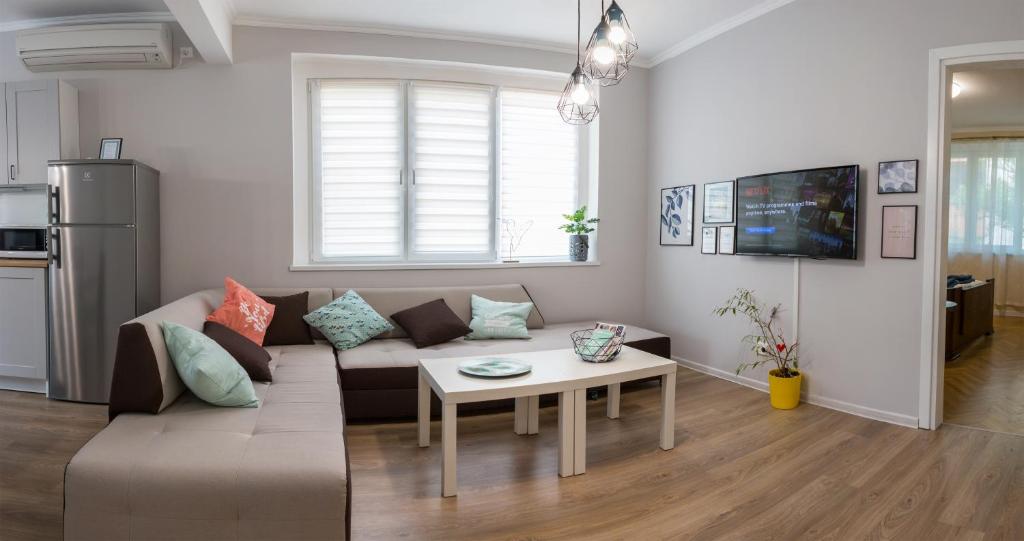 uma sala de estar com um sofá e uma mesa em Bright and Cozy 2BD. Flat in Plovdiv City Centre em Plovdiv