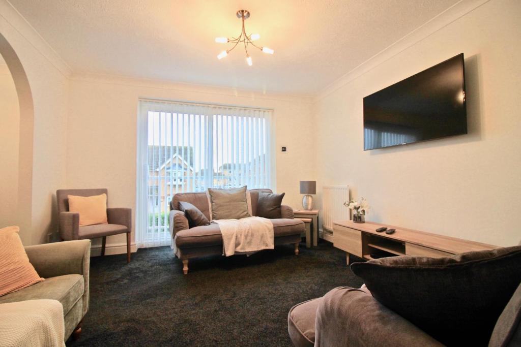 sala de estar con sofá y TV en Seascape, en Clacton-on-Sea
