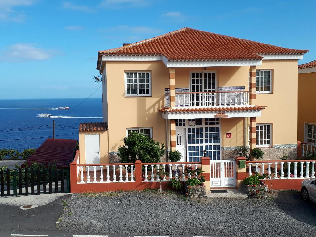 ein Haus mit einem Zaun vor dem Meer in der Unterkunft Apartamentos Casa Junonia in Alajeró