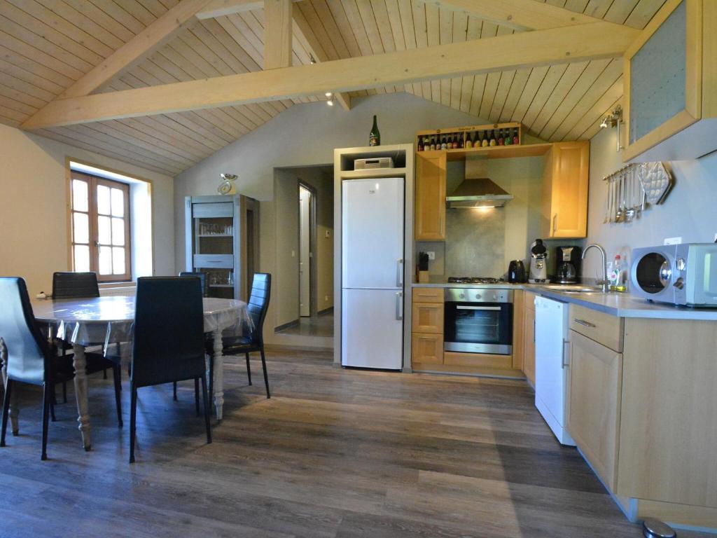 a kitchen with a table and a white refrigerator at Spacious Chalet in Vielsalm with Garden in Vielsalm