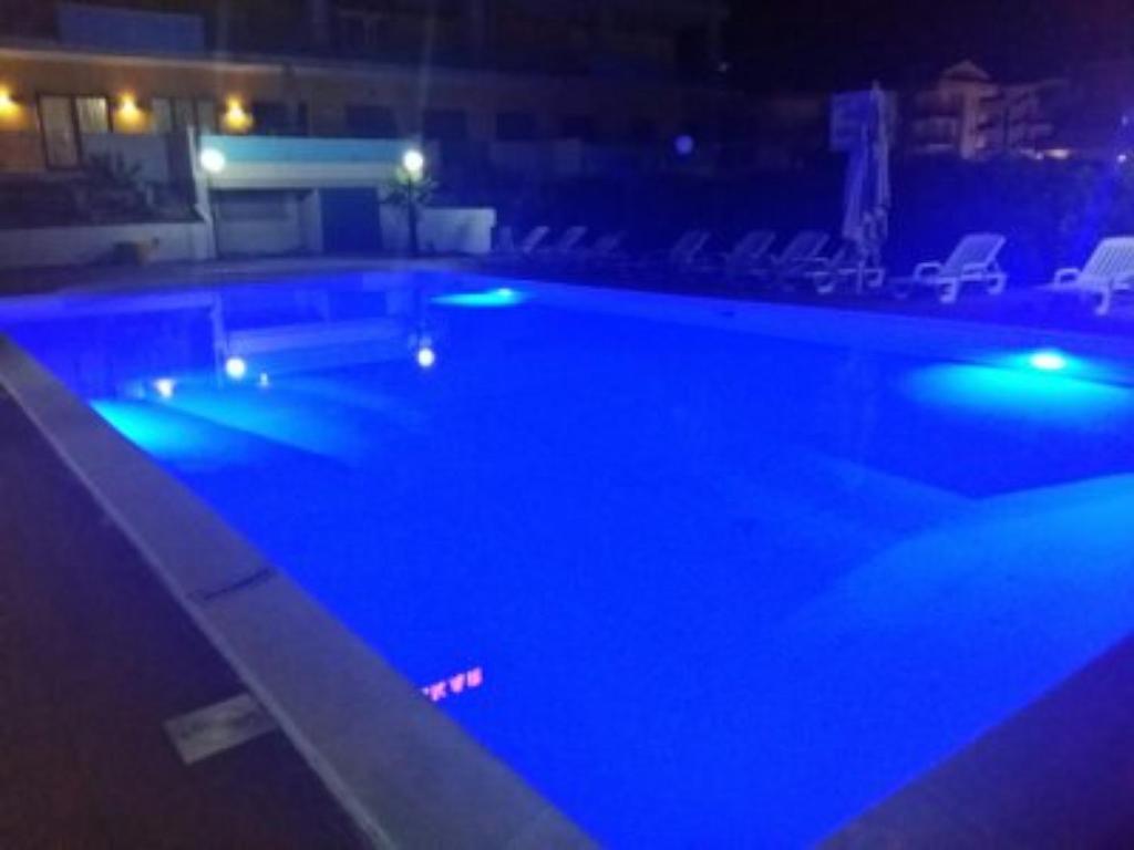 una piscina notturna con luci blu di Dakar Hotel Vasto a Vasto
