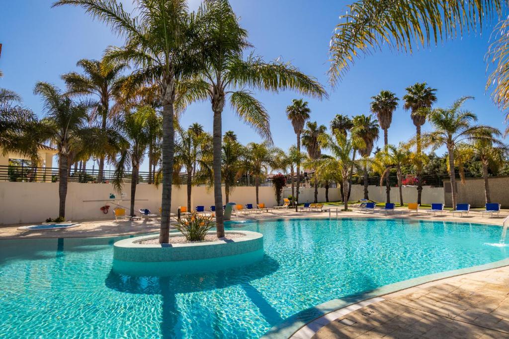 a swimming pool with palm trees in a resort at Mirachoro Carvoeiro in Carvoeiro